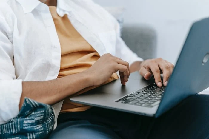 Afbeelding van iemand achter een laptop die een webtekst schrijft